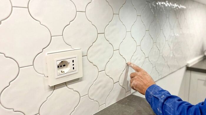 Fughe chiare epossidiche tra piastrelle arabesque del rivestimento cucina